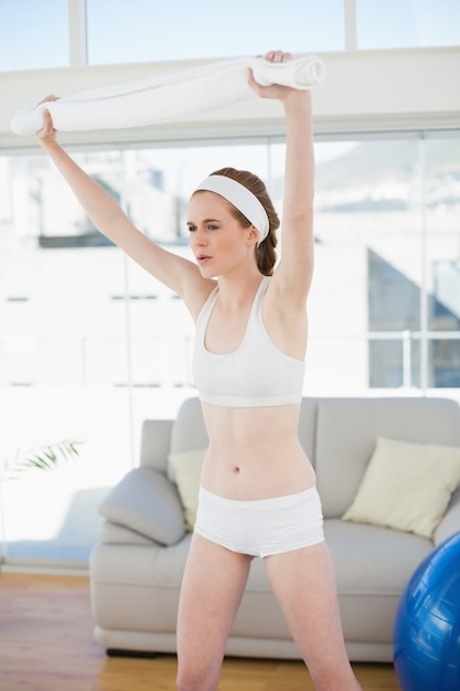 Sporty female stretching hands in fitness center