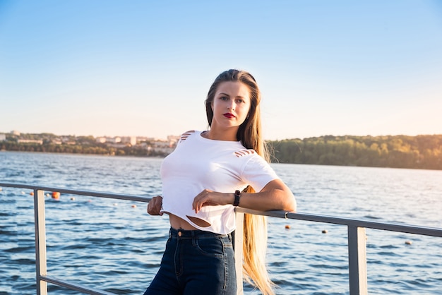 Sporty and fit woman posing on quay on sunrise