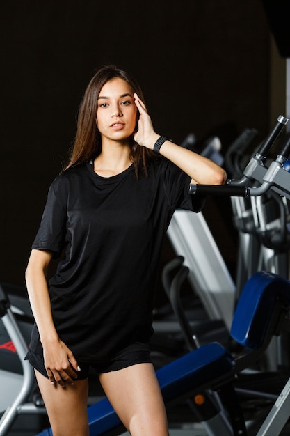 Sporty girl in fashionable sportswear stay near by sport equipment in sport club