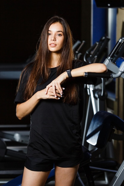 Sporty girl in fashionable sportswear stay near by sport equipment in sport club