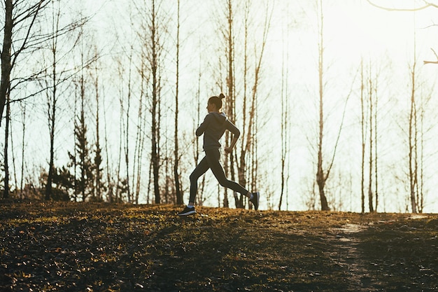 Sporty girl running on a rural road