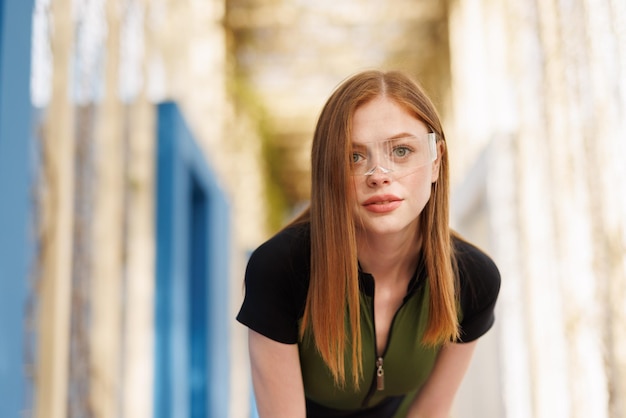 Sporty girl in sportswear is training in the park Female in modern VR glasses