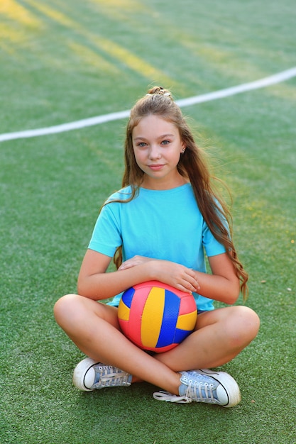 Sporty girl with a ball on the football field