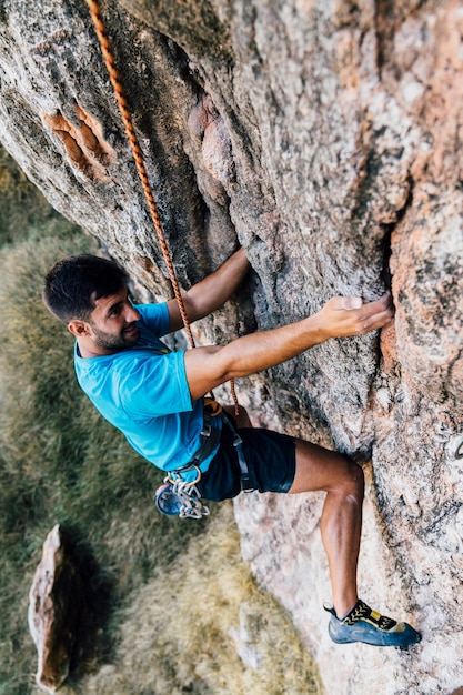 Sporty man climbing on rock