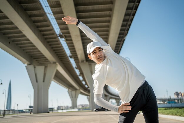 A sporty man conducts a fitness workout in the city sports comfortable clothes a smart watch