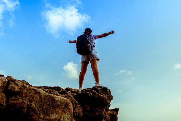 Sporty woman on the cliff. Success and goal concept. Strong and healthy for outdoor activity.