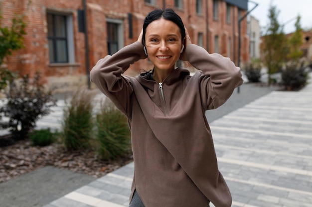 Sporty woman in headphones posing on the street