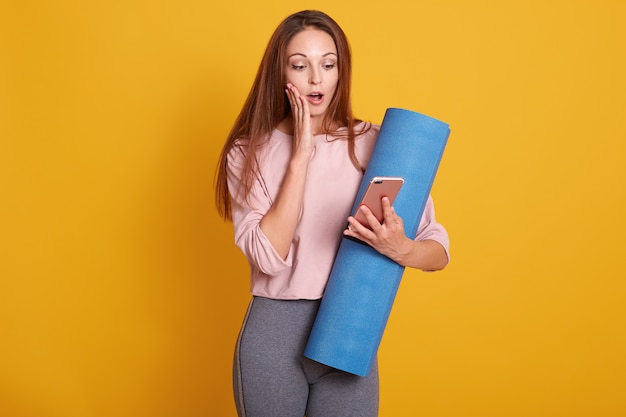 Sporty woman holding smartphone in hand