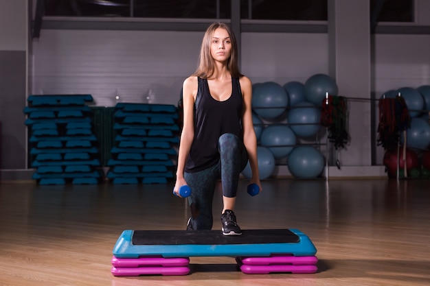 Photo sporty woman practice on step platform in gym