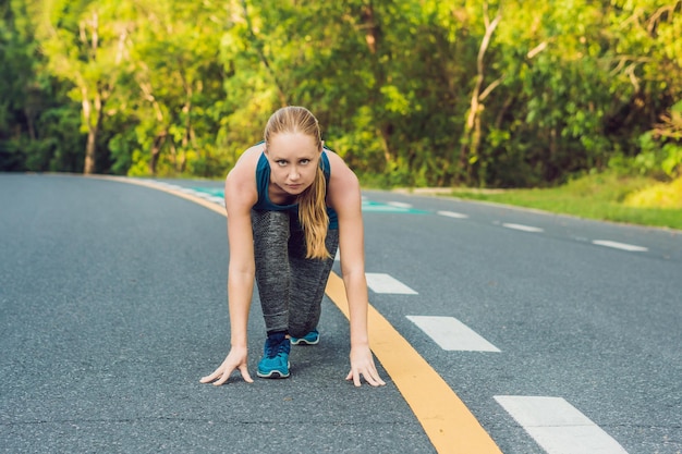 Sporty woman running on road at sunrise fitness and workout wellness concept