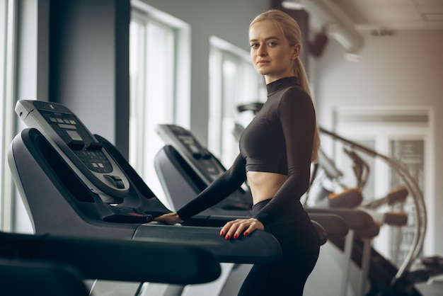 Sporty woman running on treadmill at the gym