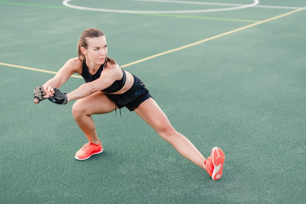 Sporty woman training and working out on the stadium in the morning