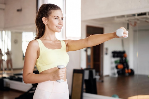 A sporty woman with a slim body trains at a fitness club Healthy lifestyle concept