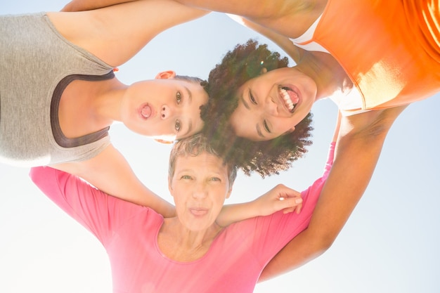 Sporty women with arms around posing down to camera 