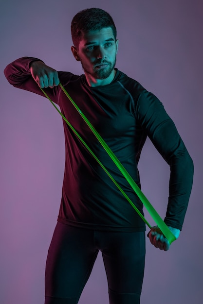 Sporty young man working out with resistance loop band