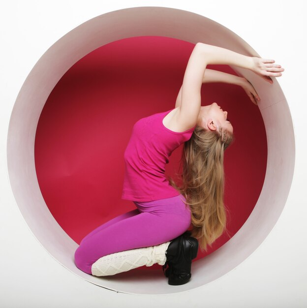 Sporty young woman posing in pink circle