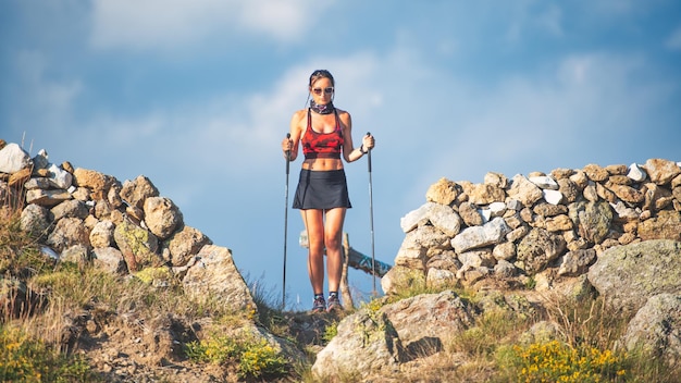 A sporty young woman with trekking sticks