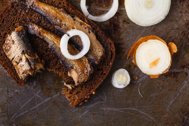 Sprat on a piece of black bread. Fish with bread