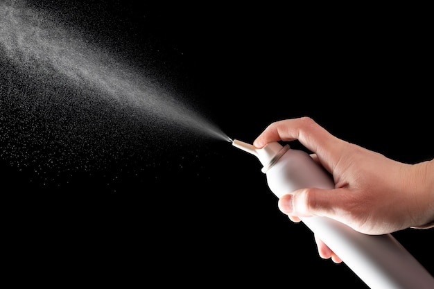 Spraying spray with salt sea water for treating rhinitis isolated on black background