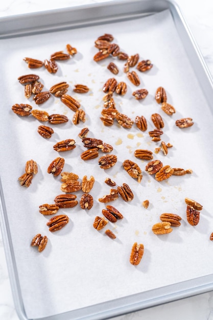 Spreading organic pecans on a baking sheet lined with parchment paper to make toasted pecans