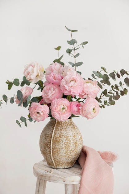 Photo spring bouquet of peonies and ranunculus in a beige vase selective focus image