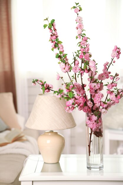 Spring bouquet in vase on table on home interior background