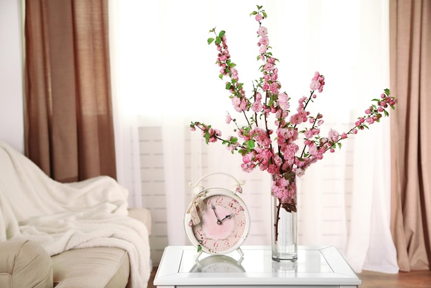 Spring bouquet in vase on table on home interior background