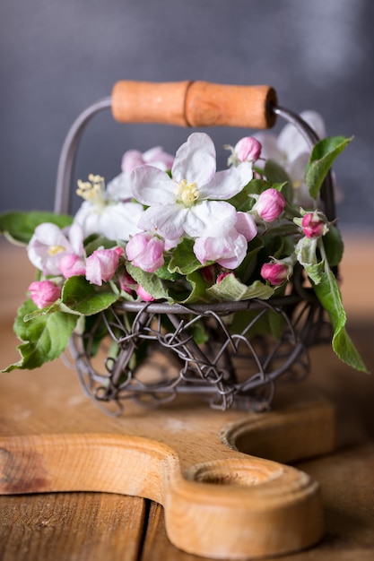 Spring. branches of a blossoming apple-tree in a basket on a wooden background