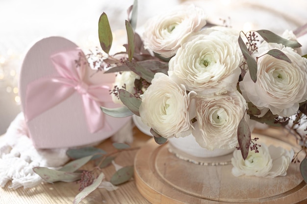 Spring composition with flowers and a gift box on a blurred background