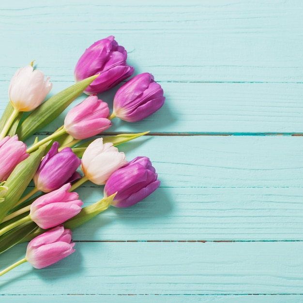 Spring flowers on blue mint wooden background