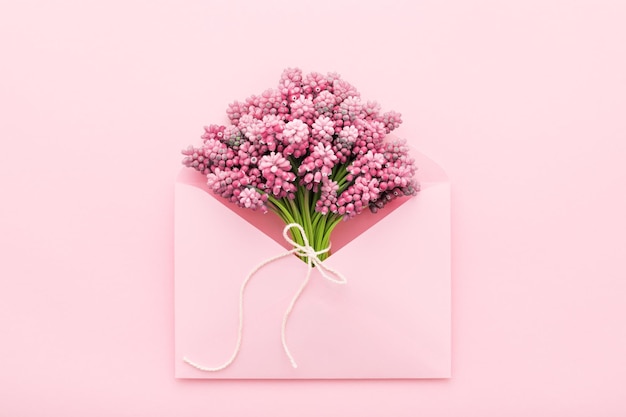 Spring flowers in a pink envelope for Mother's day flat lay