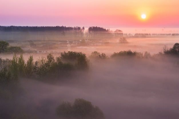 Photo spring fog over the village at sunrise