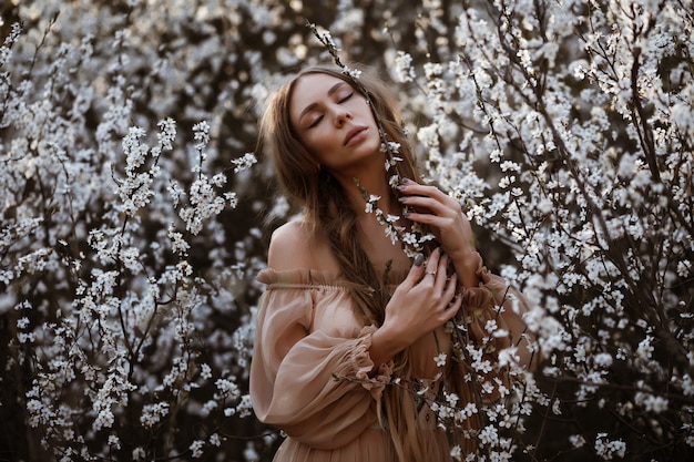 spring and girl. beautiful portrait of a model with closed eyes in white colors