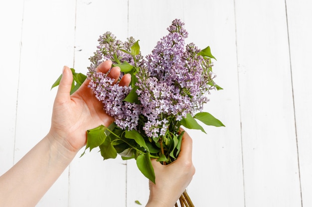 Spring lilac bouquet in the woman hands