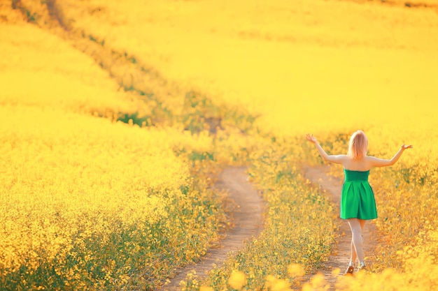 spring nature young girl in a field of flowers, freedom and happiness of a lady in a sunny landscape