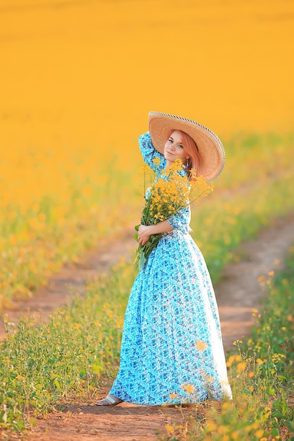 spring nature young girl in a field of flowers, freedom and happiness of a lady in a sunny landscape