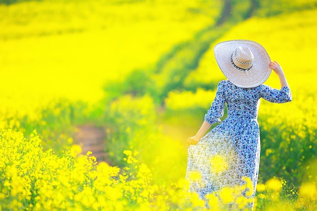 spring nature young girl in a field of flowers, freedom and happiness of a lady in a sunny landscape