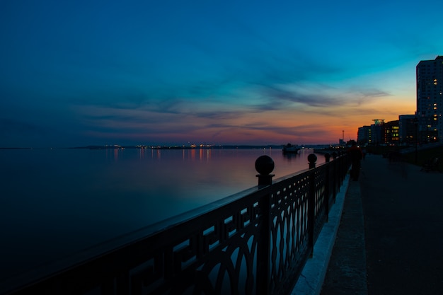 Spring night city Saratov quay under sunset. Street decorative lights and beautiful sky