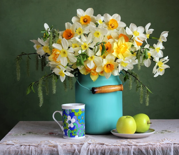 Spring retro still life with garden daffodils and green apples.