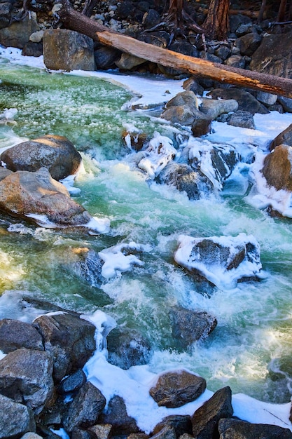 Spring river at Yosemite filled with snow and frosted rocks