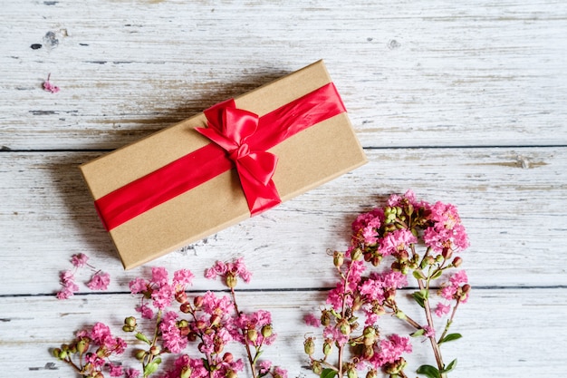 Spring Rustic background with gift box and pink flowers