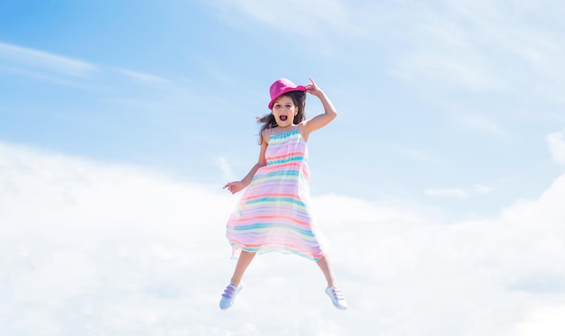 Spring season weather summer fashionable look freedom beautiful teen girl jump in hat kid fashion style female natural beauty happy childhood cute child on sky background Fashion is her life