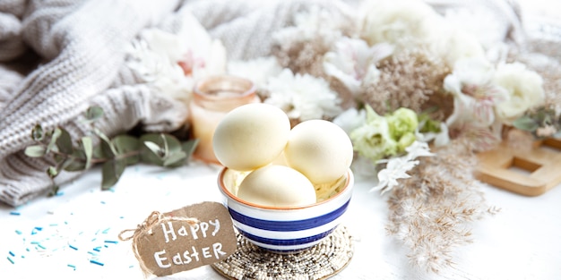 Spring still life with Easter eggs in a beautiful saucer against decor details. Easter holiday concept.