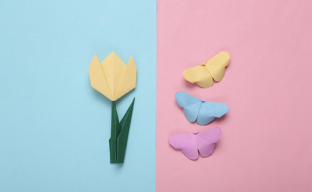 Spring or summer composition of origami tulips and butterflies on pink blue background