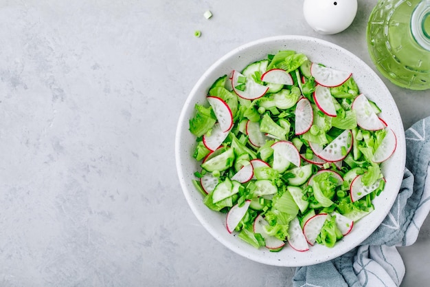 Spring vegetable salad Fresh radish cucumber salad with green lettuce in bowl