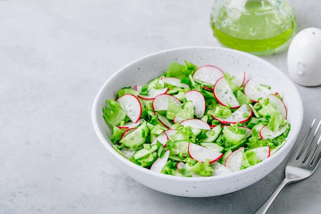 Spring vegetable salad Fresh radish cucumber salad with green lettuce in bowl