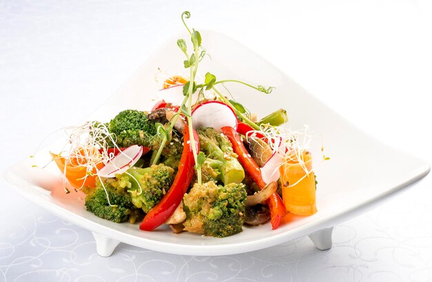 Spring vegetable salad Peppers carrots broccoli and radishes On white background