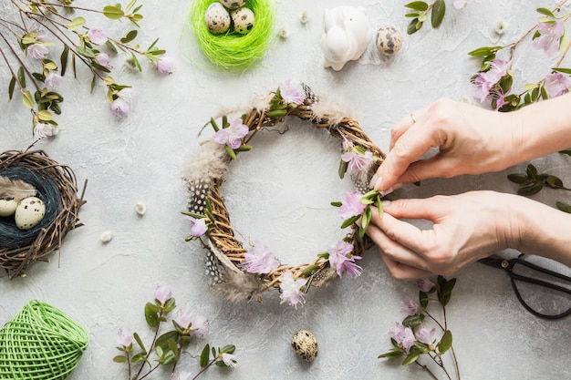 Spring wreath with flowers on light. Creative flat lay. Top view. Decor handmade. Woman decorated.