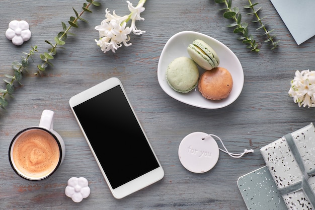 Springtime flat lay with pearl hyacinth flowers, eucalyptus, mobile phone and cards