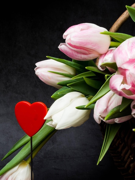 Springtime flowers and basket against grey background